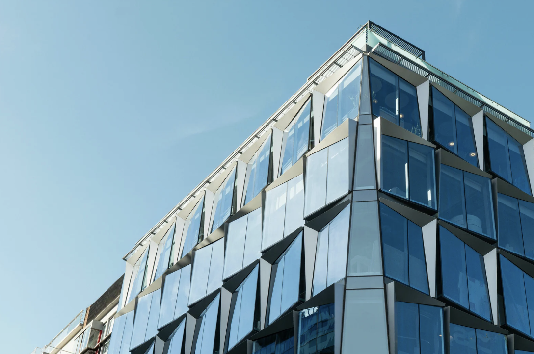 Moderne Glasfassade eines Bürogebäudes in Hamburg im ersten Morgenlicht