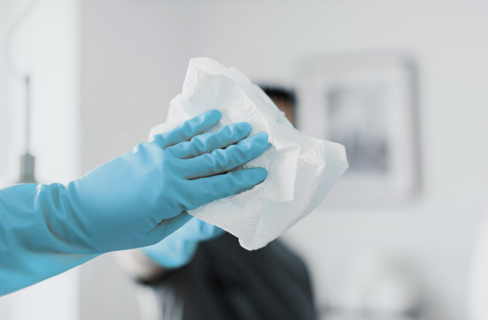Reinigungskraft mit Handschuhen bei präziser Detailarbeit